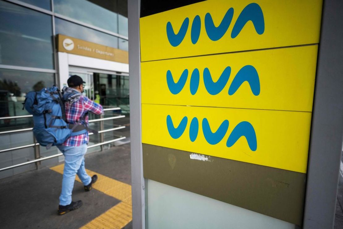 Un hombre pasa junto a una valla publicitaria de Viva Air a las afueras del aeropuerto internacional El Dorado de Bogotá el 28 de febrero de 2023.