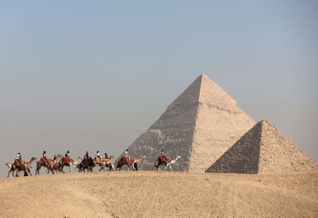 Los turistas montan camellos frente a la meseta de las grandes pirámides en Guiza, Egipto, en diciembre. Crédito: Amr Abdallah Dalsh/Reuters