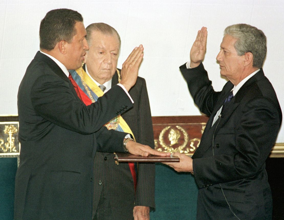 El presidente electo de Venezuela, Hugo Chávez, es juramentado por el presidente del Congreso de Venezuela, Luis Alfonso Dávila, el 2 de febrero durante su ceremonia de investidura en Caracas. En el centro está el presidente saliente Rafael Caldera. Crédito: RODRIGO ARANGUA/AFP vía Getty Images Crédito: RODRIGO ARANGUA/AFP via Getty Images