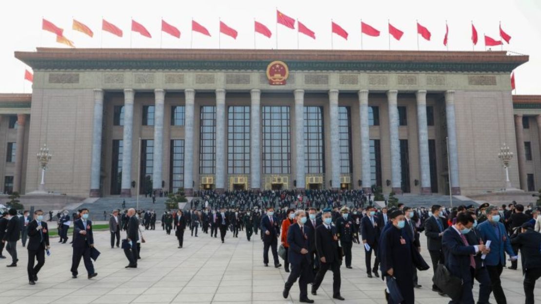 Gente camina frente al Gran Salón del Pueblo el 4 de marzo de 2023, en Beijing, mientras comienza la reunión anual conocida como las Dos Sesiones.