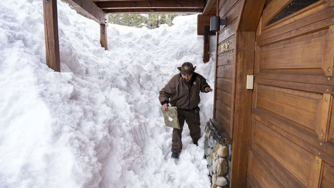 Juan Hernandez, repartidor de UPS, entrega un paquete en una casa cubierta de nieve en Truckee, California, el viernes.