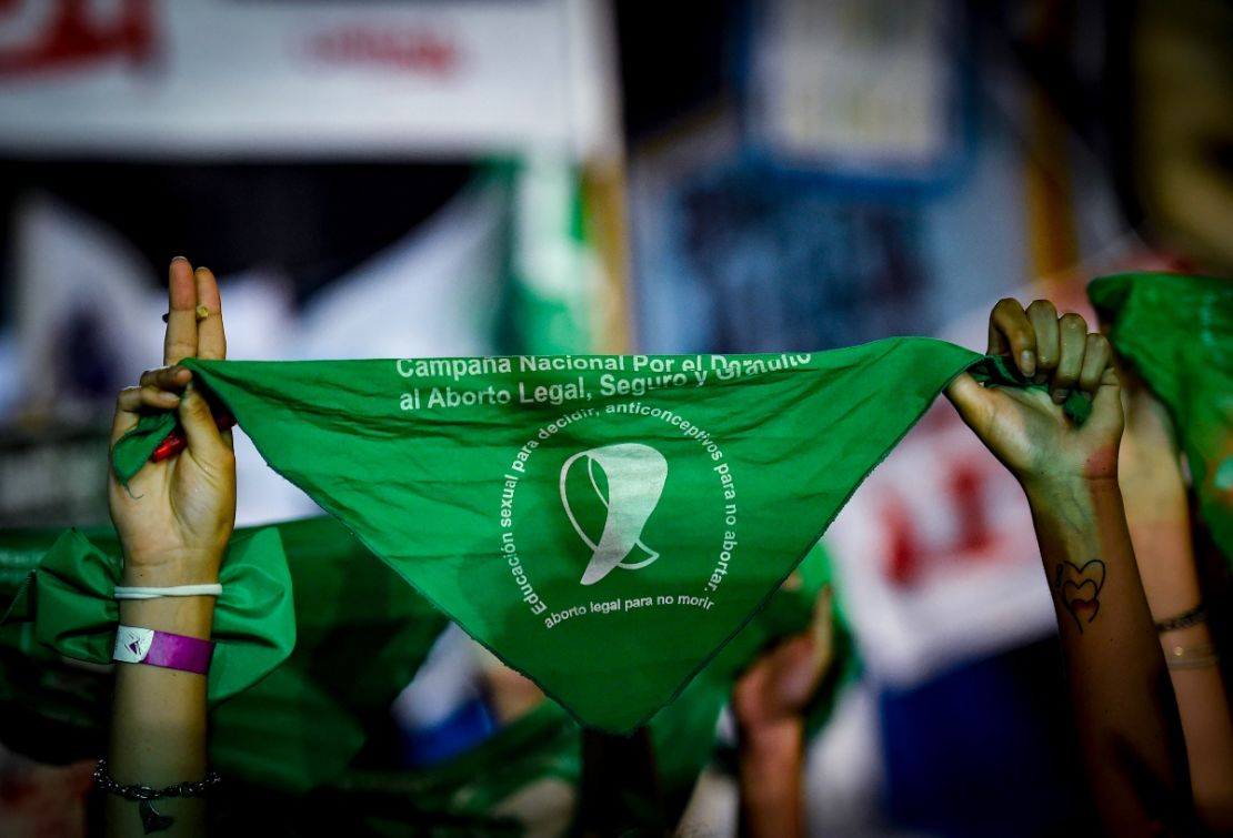 Una manifestante a favor del aborto levanta un pañuelo verde frente al Congreso Nacional mientras los senadores deciden sobre la legalización del aborto el 29 de diciembre de 2020 en Buenos Aires, Argentina.