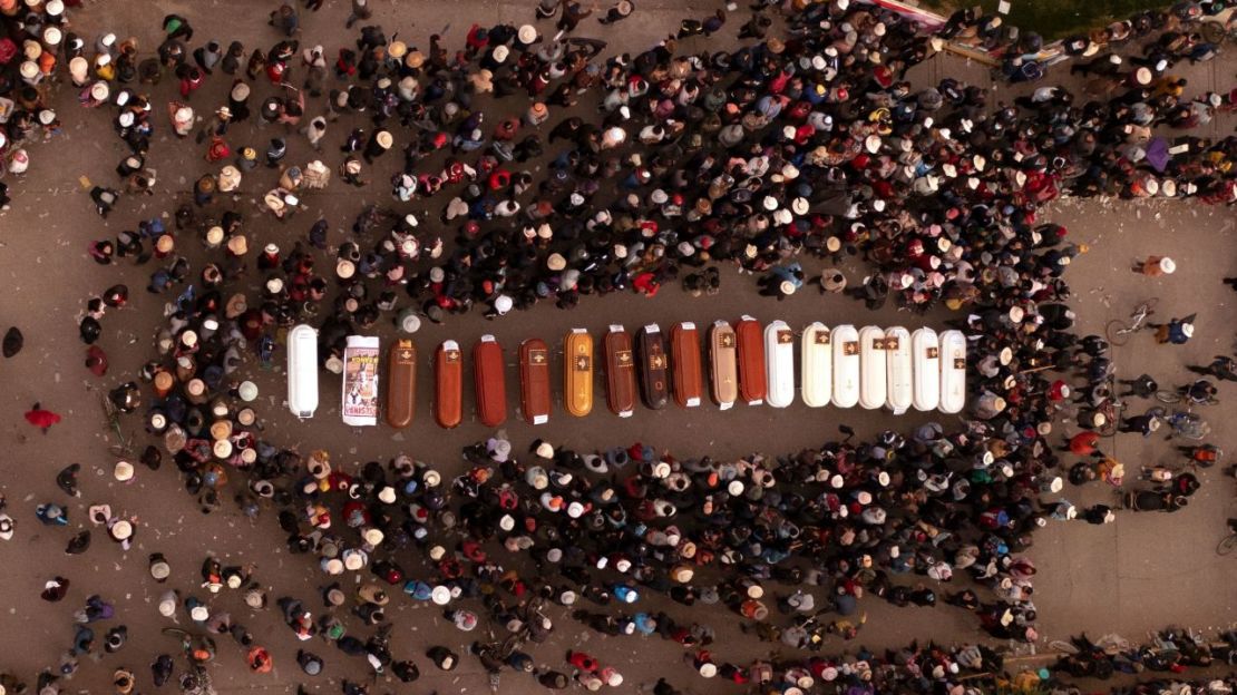 Varias personas rodean los ataúdes de los fallecidos durante los disturbios en Juliaca, Perú.