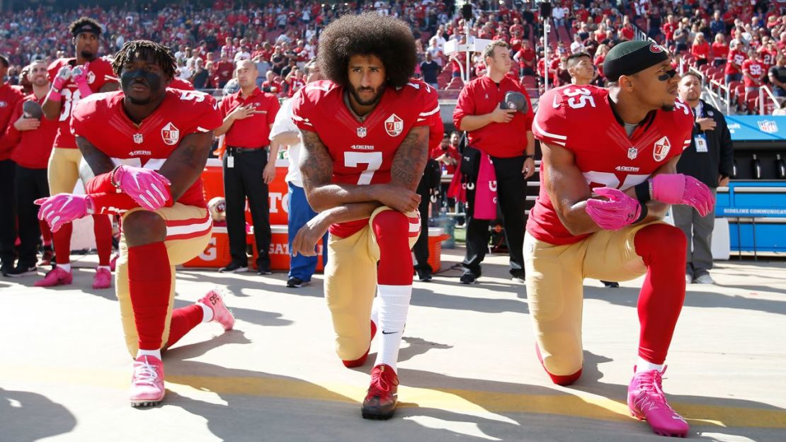 Eli Harold #58, Kaepernick #7 y Eric Reid #35 de los San Francisco 49ers se arrodillan para el himno antes del partido contra los Buccaneers de Tampa Bay en el Levi Stadium el 23 de octubre de 2016 en Santa Clara, California. Crédito: Michael Zagaris/San Francisco 49ers/Getty Images