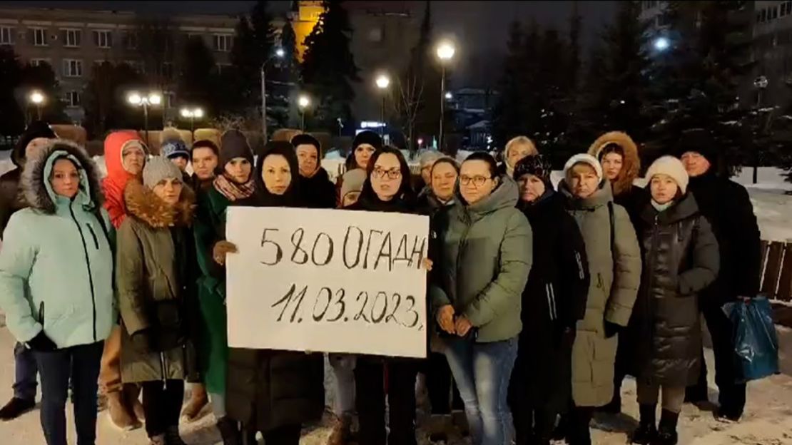 El grupo sostiene un cartel en ruso que decía: "División Separada de Artillería de Obús 580".