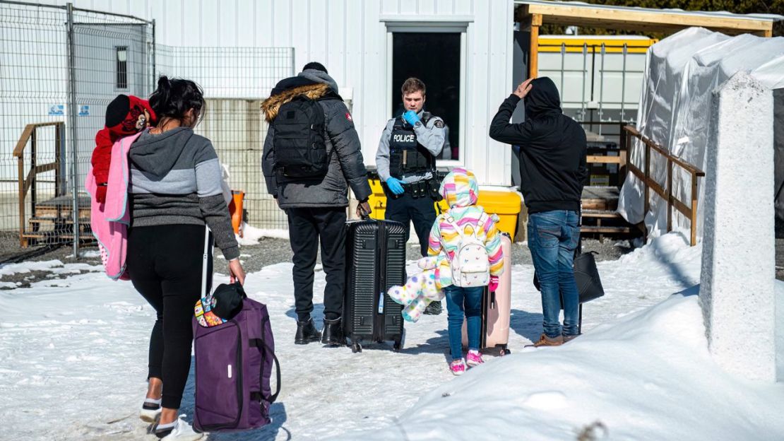 Un agente habla con migrantes a su llegada al paso fronterizo de Roxham Road en Roxham, Quebec, Canadá, el 3 de marzo de 2023. Crédito: Sebastien St-Jean/AFP/Getty Images