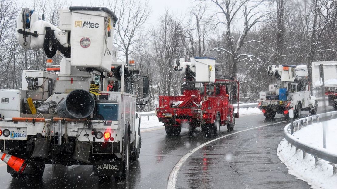 Equipos de reparación de servicios públicos en Albany, Nueva York, hacen una caravana durante la tormenta del martes.