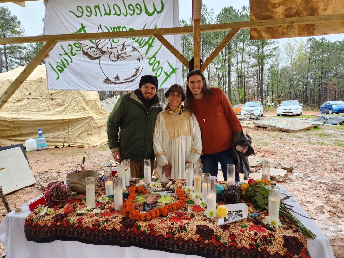 Belkis y su hijo Pedro sonríen ante un altar improvisado con velas y un retrato de Manuel Esteban en el campamento de protesta en el sureste de la ciudad de Atlanta.