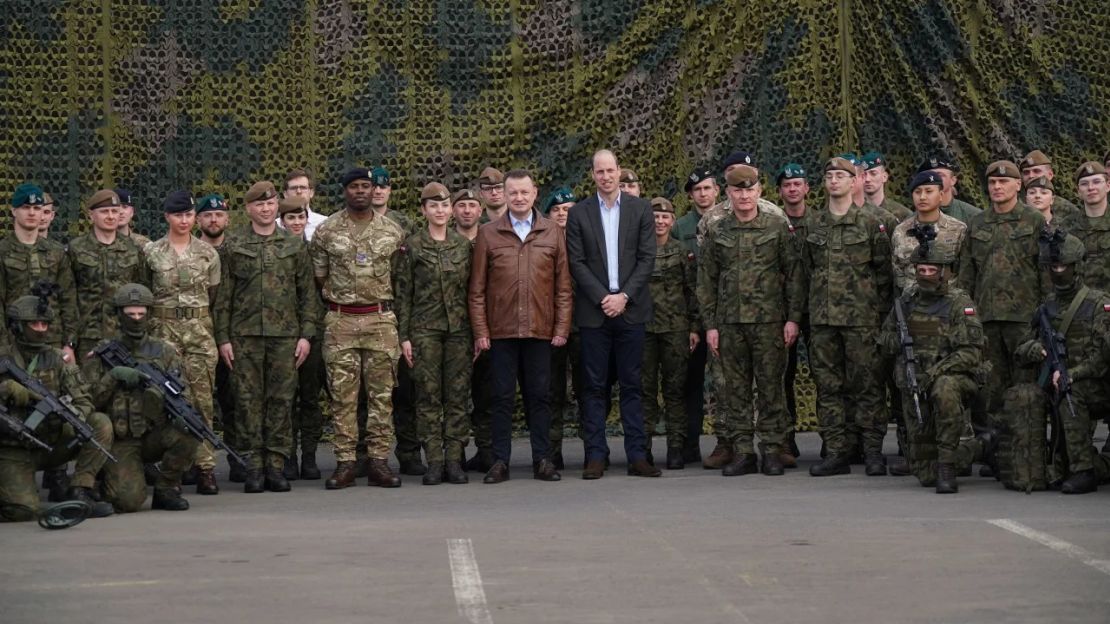 El príncipe William y el viceprimer ministro y ministro de Defensa de Polonia, Mariusz Blaszczak (centro izquierda), posan para una foto grupal con tropas británicas y polacas. Crédito: Yui Mok/AP