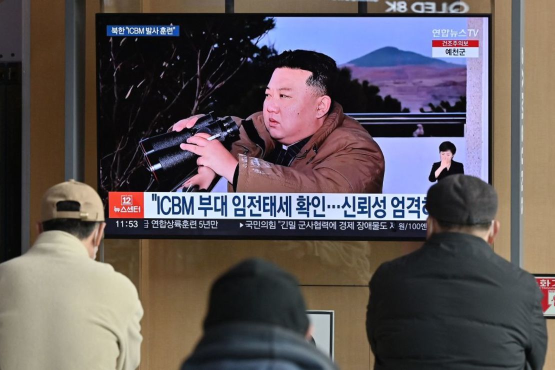 La gente mira una pantalla de televisión que muestra una imagen del líder de Corea del Norte, Kim Jong Un, presenciando el lanzamiento de prueba reciente de un misil balístico intercontinental (ICBM) Hwasong-17, en una estación de tren en Seúl el 17 de marzo de 2023.