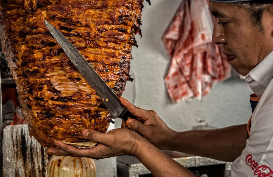 El chef Adrián Reyes corta la carne de un trompo de pastor, carne de cerdo marinada, en el restaurante El Tizoncito. Crédito: Omar Torres/AFP/Getty Images