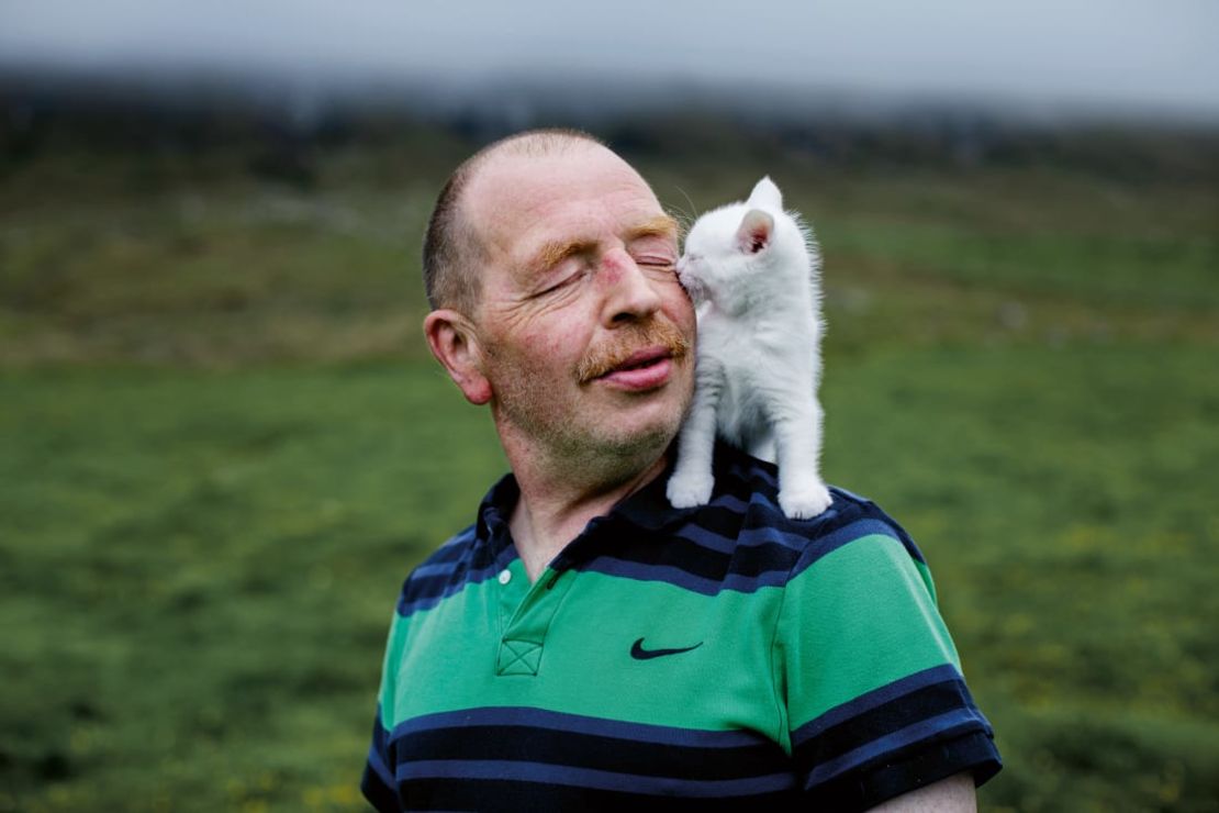 Uno de los sujetos de Gjestvang, Andrias, de 54 años, es fotografiado con su gatito fuera de su casa en Vidareidi. Estudió en Dinamarca antes de regresar a las islas Feroe y comprar un barco. Crédito: Andrea Gjestvang/GOST Books