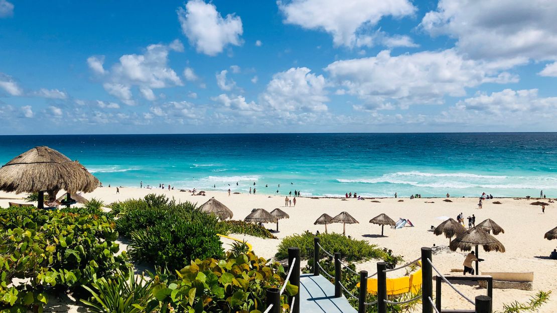 Vista de la playa desde uno de los accesos en Cancún, Quintana Roo, uno los principales destinos turísticos de México, famoso por sus aguas turquesas y sus playas caribeñas de arena blanca.