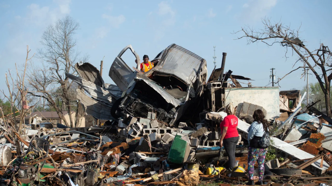 KeUntey Ousley intenta salvar las pertenencias del vehículo del novio de su madre mientras su mamá LaShata Ousley y su novia Mikita Davis observan en Rolling Fork, Mississippi, donde un tornado había golpeado.