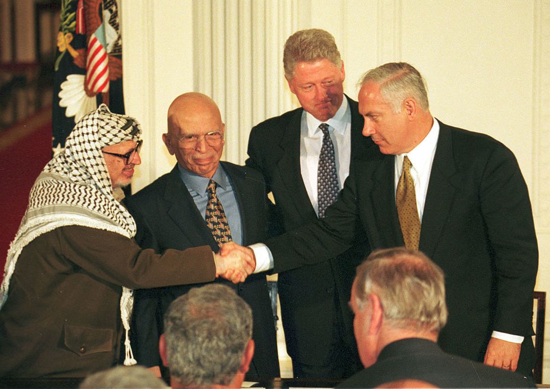 El presidente de EE.UU., Bill Clinton,y el Rey Hussein de Jordania asisten al apretón de manos entre el primer ministro de Israel Benjamin Netanyahu y el presidente de la Autoridad Nacional Palestina Yasser Arafat el 23 de octubre de 1998.