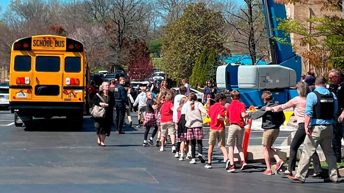 Niños de la primaria Covenant en Nashville, Tennessee, se toman de la mano mientras son llevados a un sitio de reunificación en la Iglesia Bautista Woodmont después de un tiroteo el 27 de marzo de 2023.