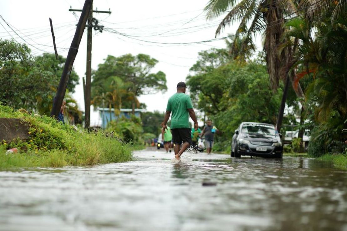 Los residentes caminan por las calles inundadas en la ciudad capital de Fiji, Suva, en diciembre de 2020 cuando se acercaba Cylone Yasa. Leon Lord/AFP/Getty Images