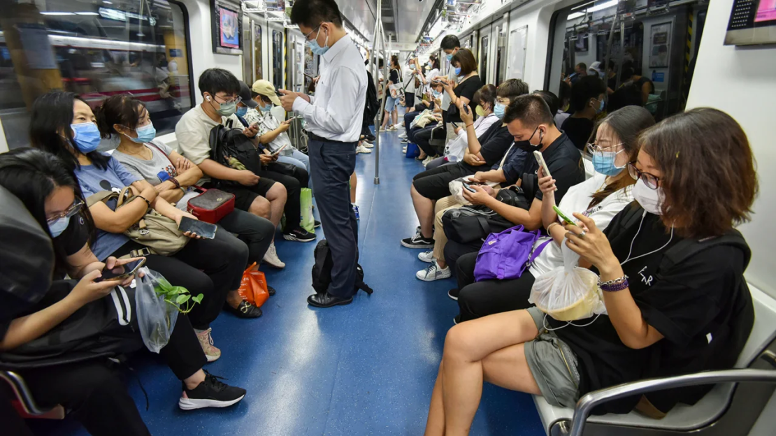 Gente usando sus teléfonos en el metro de Beijing en julio de 2022.