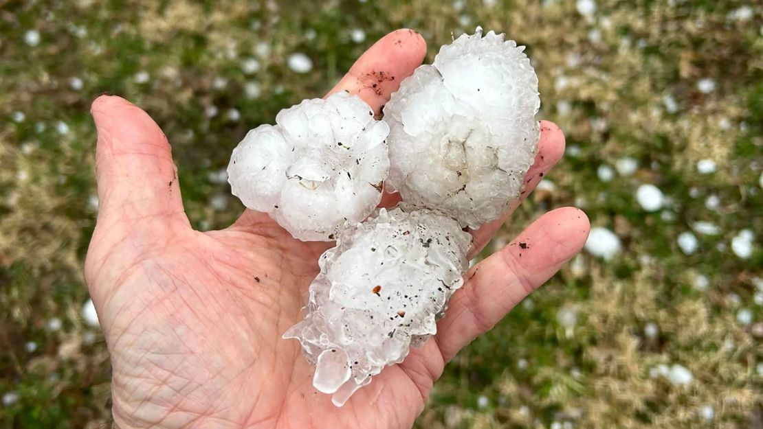 Un hombre sostiene granizo grande en Davenport, Iowa, que vio granizo del tamaño de pelotas de béisbol en algunos casos.