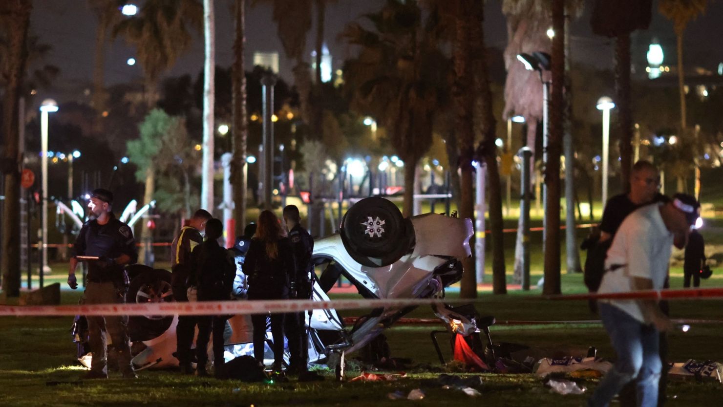 La policía de Israel rodea un automóvil volcado en el lugar de un ataque en Tel Aviv el 7 de abril de 2023.