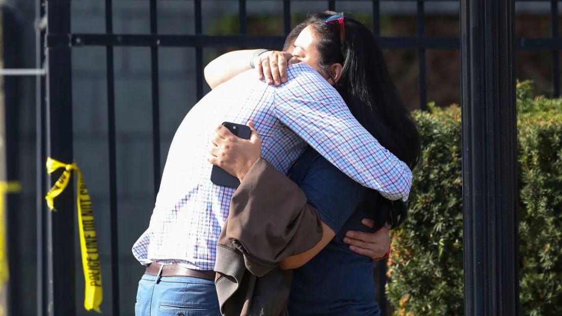 Dos personas se abrazan en el exterior del edificio donde el lunes se produjo un tiroteo masivo en Louisville. Crédito: Michael Clevenger/Courier Journal/AP