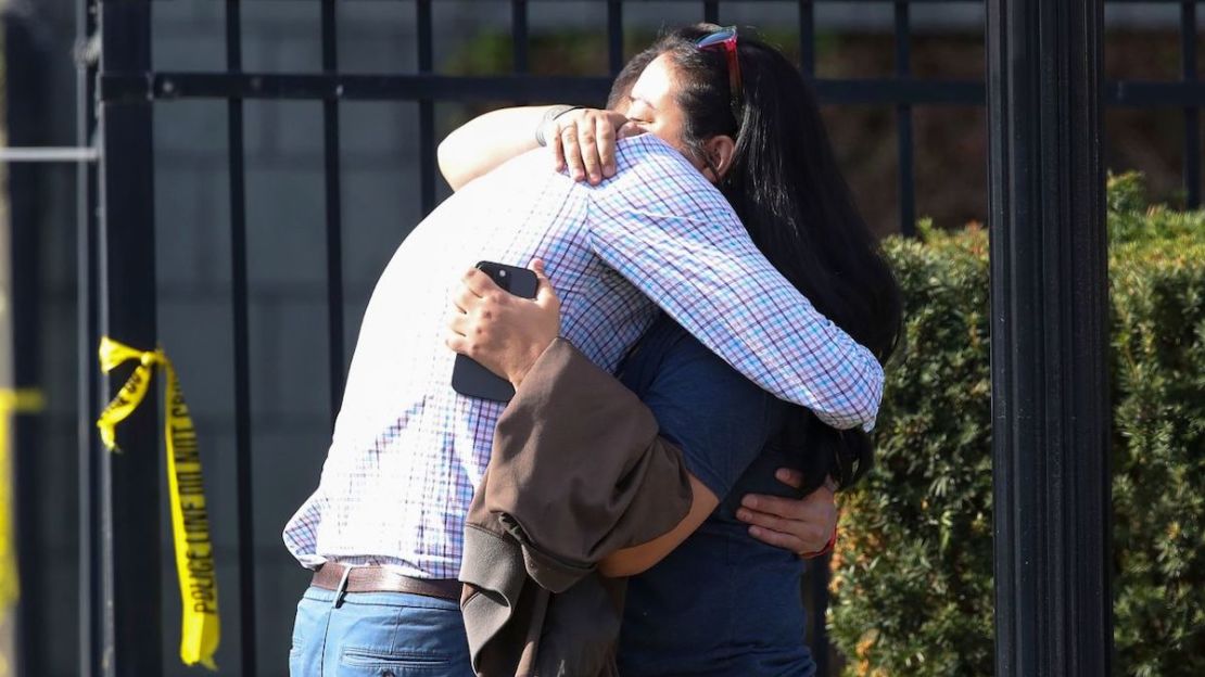 Dos personas se abrazan el lunes afuera del edificio donde ocurrió un tiroteo masivo en Louisville. Michael Clevenger/Courier Journal/AP