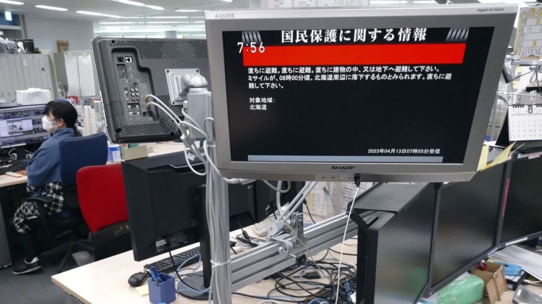 Una pantalla en una oficina de Tokio muestra este jueves por la mañana un comunicado del gobierno japonés en el que se advierte a los ciudadanos de la isla principal de Hokkaido que se pongan a cubierto inmediatamente y permanezcan en el interior de los edificios, diciendo que era probable que un misil cayera cerca de la isla.