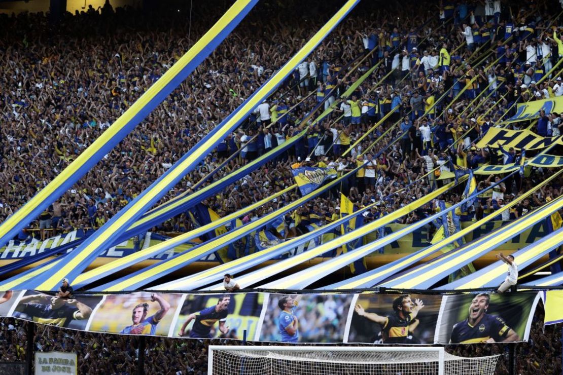 Hinchas de Boca Juniors son vistos con banderas con retratos del ex jugador de Boca Juniors y entrenador de Platense Martín Palermo.