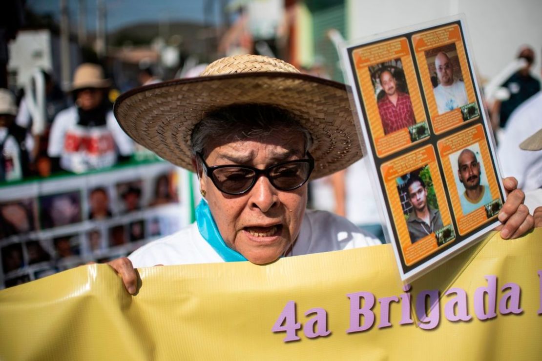 La mexicana María Herrera sostiene los retratos de sus hijos durante una marcha el 20 de enero de 2019.