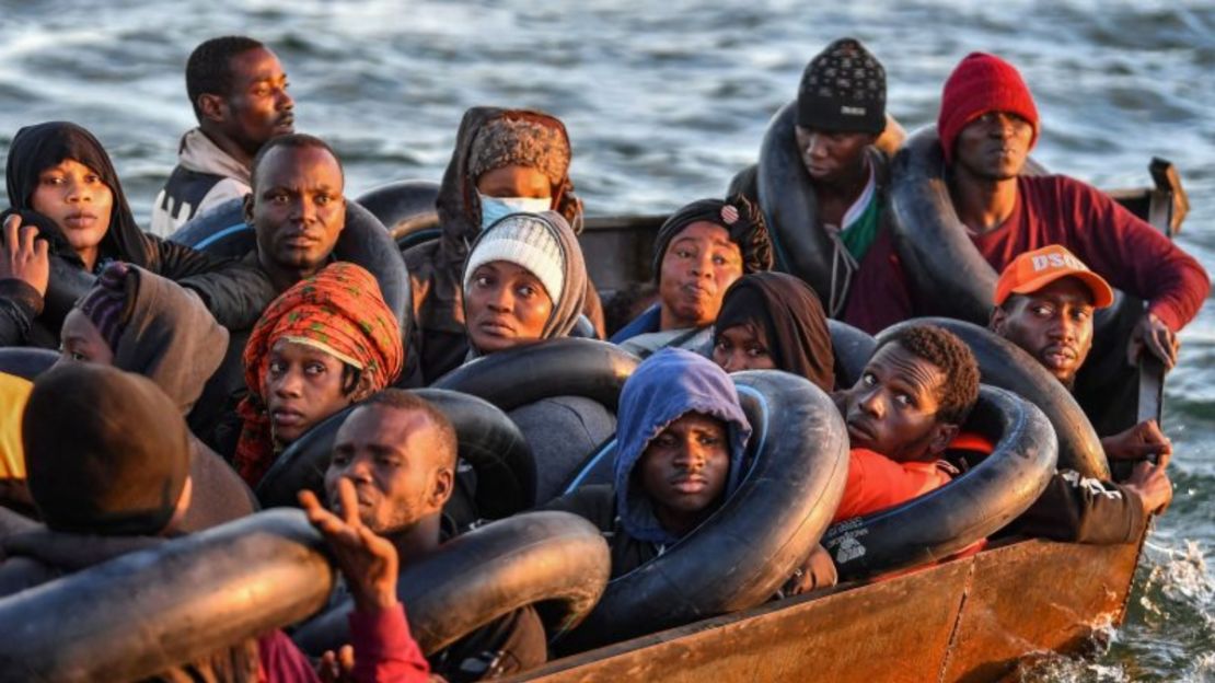 Migrantes del África subsahariana, imágenes del 4 de octubre de 2022, sentados en un bote improvisado mientras viajan hacia la costa italiana.