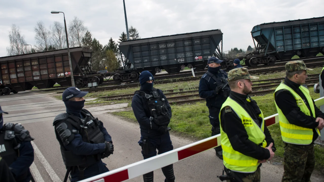 Policías y guardias fronterizos protegen un tren que transporta grano ucraniano en el cruce de la línea ferroviaria de vía ancha de Hrubieszow, Polonia, el 12 de abril de 2023.