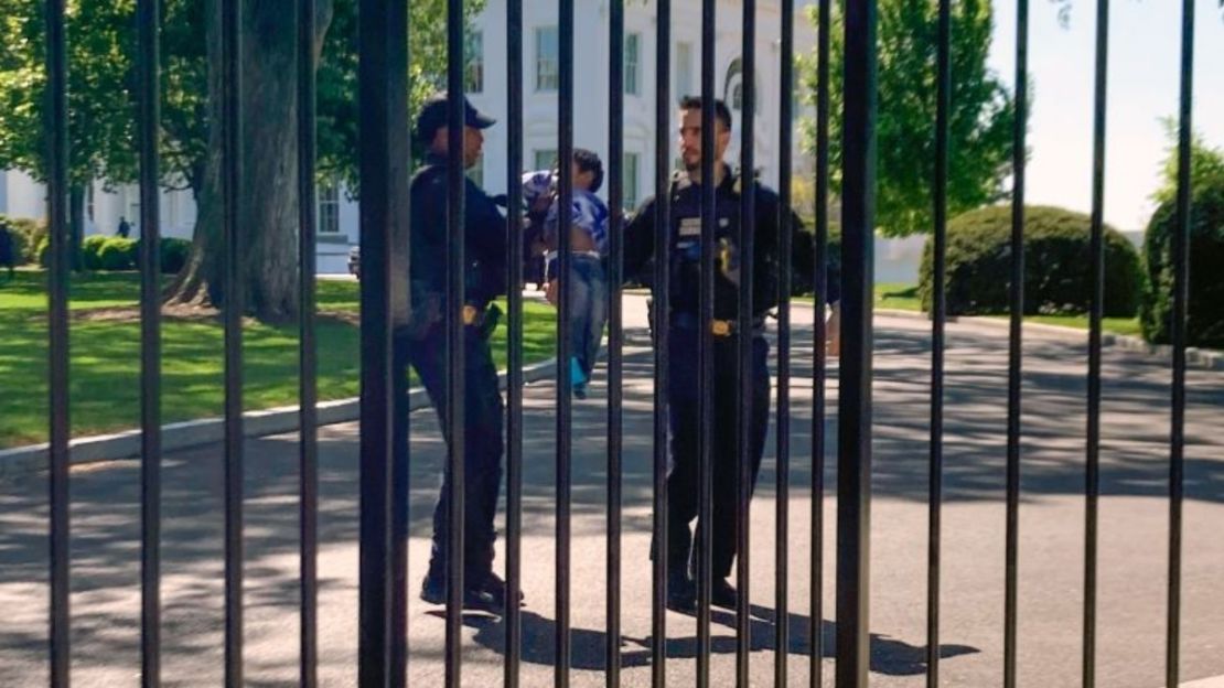 Agentes de policía de la división uniformada del Servicio Secreto cargan a un niño pequeño que se arrastró a través de la cerca de la Casa Blanca el martes 18 de abril de 2023.