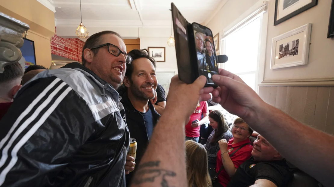 Rudd aparece en fotografías junto a aficionados del Wrexham en The Turf Pub, antes del partido del sábado.