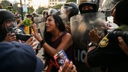 A demonstrator shouts next to riot police during a protest against the government of Peru's President Dina Boluarte, in Lima on March 04, 2023. (Photo by Ernesto BENAVIDES / AFP)