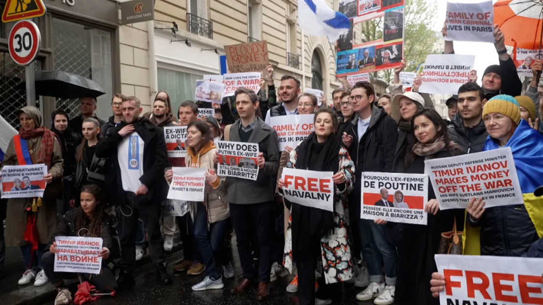 Manifestantes con pancartas frente a un edificio de apartamentos de lujo en París el 23 de abril, donde se cree que Svetlana Maniovich tiene un apartamento.