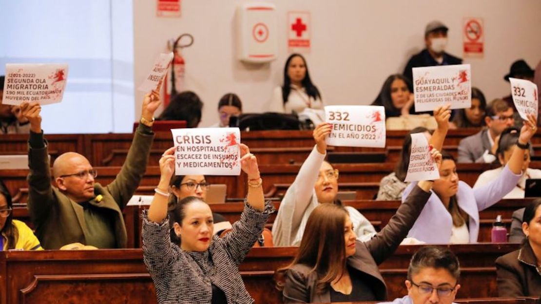 Asambleístas opositores levantan pancartas en protesta por problemas del país como la migración, la crisis sanitaria, el feminicidio y el aumento de la violencia durante una audiencia en Quito, el 26 de abril.