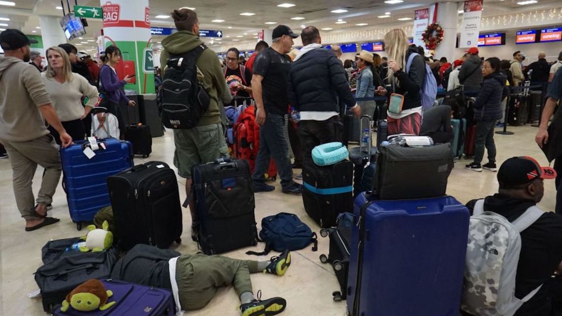 Foto de archivo. Viajeros hacen fila para revisar sus vuelos de la aerolínea Sunwing en la terminal 2 del aeropuerto internacional de Cancún en Cancún, estado de Quintana Roo, México, el 27 de diciembre de 2022. Para ese momento, muchos vuelos habían sido cancelados o retrasados debido al mal tiempo en Canadá y Estados Unidos.