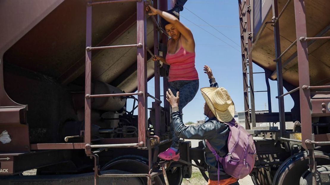 Familiares ayudan a una mujer a bajar del tren después de que se asustara y no pudiera descender del techo.