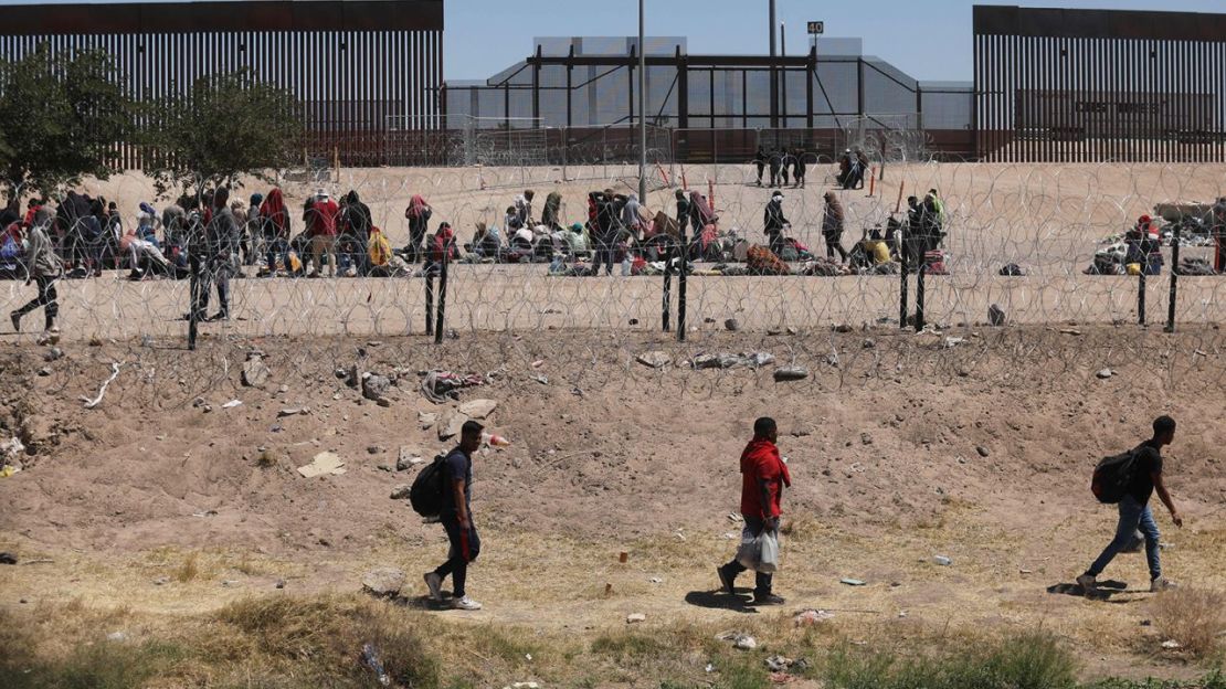 Migrantes acampan a orillas del río Grande mientras esperan ser procesados por la Patrulla Fronteriza Sector El Paso, Texas, después de cruzar desde Ciudad Juárez, México, el 8 de mayo de 2023.