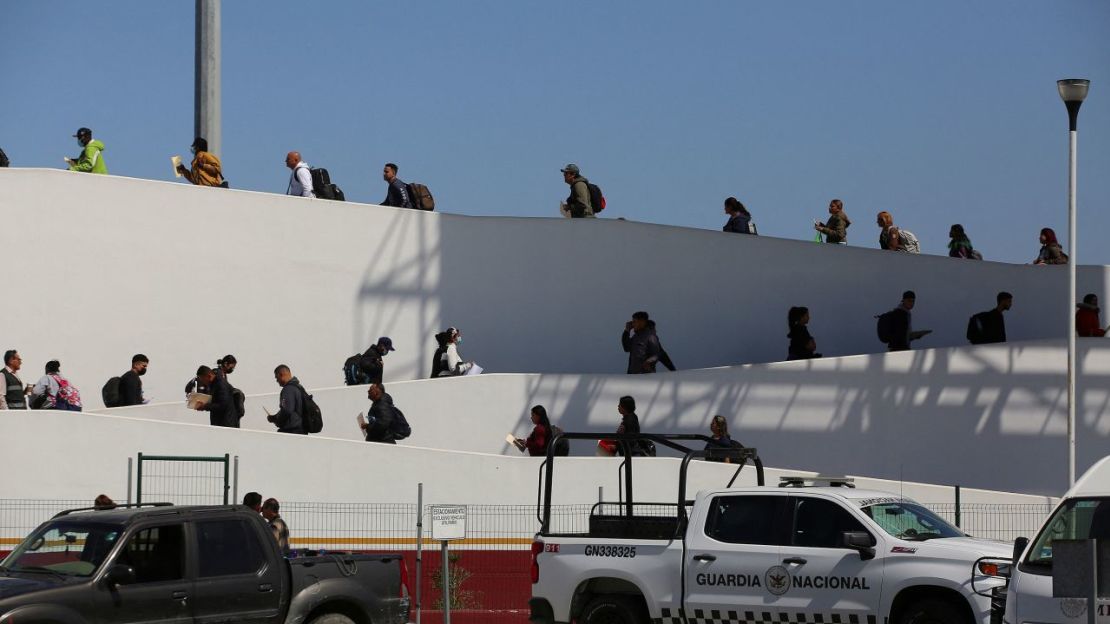 Migrantes que solicitaron una cita para asilo en Estados Unidos usando la aplicación CBP ONE cruzan el puerto de entrada El Chaparral en Tijuana, México, el 9 de mayo de 2023.