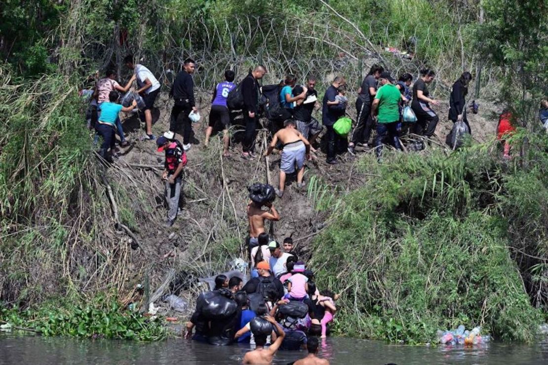 Migrantes intentan llegar a EE. UU. a través del Río Grande, que está reforzado con una cerca de alambre de púas, visto desde Matamoros, México, el miércoles.