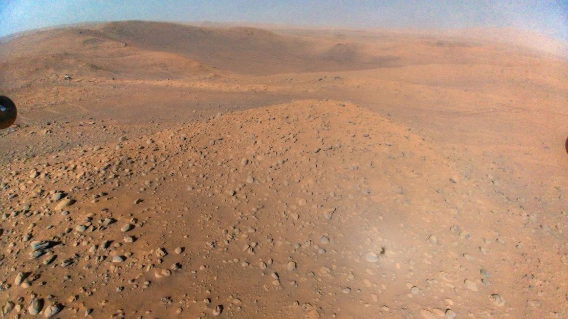 El helicóptero Ingenuity, que sirve de explorador aéreo para el rover, tomó una foto de Perseverance durante su 51° vuelo el 22 de abril. El rover puede verse en la parte superior izquierda de la imagen. Crédito: NASA/JPL-Caltech