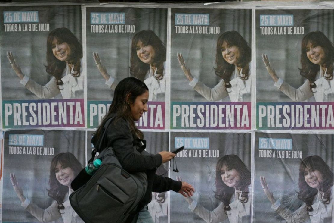 Una mujer pasa junto a pancartas con el retrato de la vicepresidenta de Argentina, Cristina Fernández de Kirchner, en las que se lee "Presidenta" y se invita a sus seguidores a una manifestación que se celebrará el 25 de mayo.