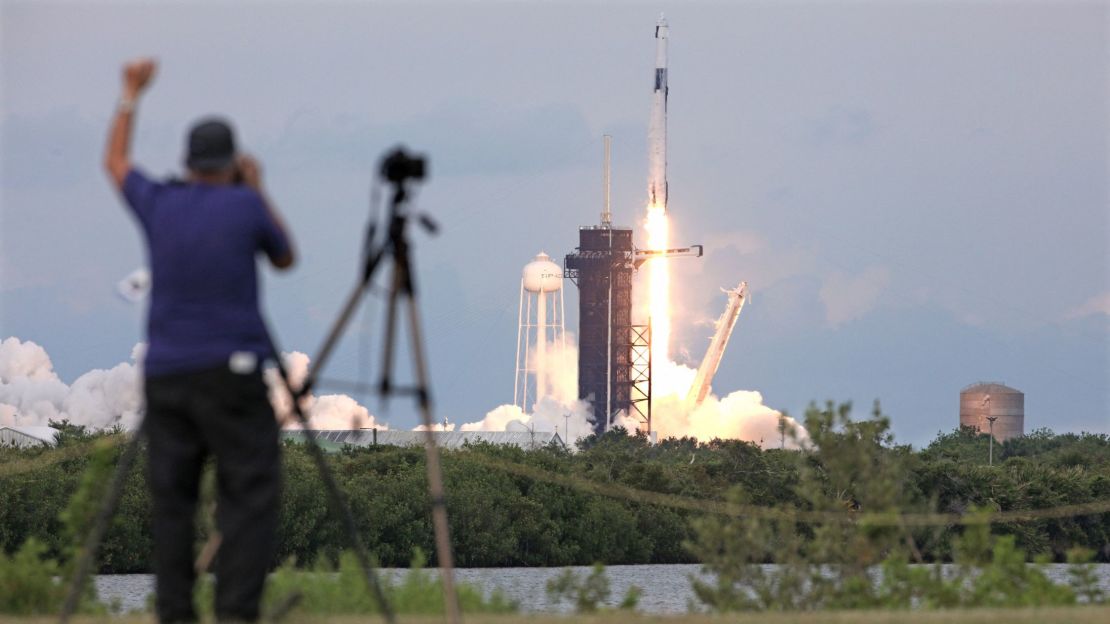 Un fotógrafo aplaude el despegue del cohete Falcon 9 de SpaceX que transporta a la tripulación de la misión AX-2 desde la plataforma 39A del Centro Espacial Kennedy de la NASA, en Florida, el 21 de mayo de 2023.