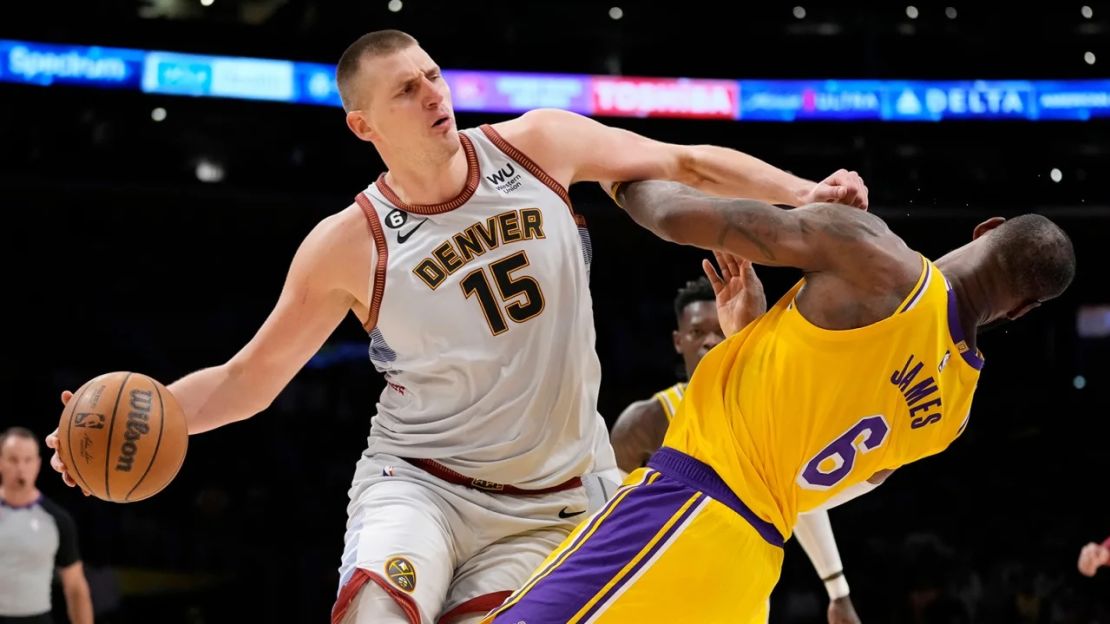 El centro de los Denver Nuggets, Nikola Jokic, choca con el alero de Los Angeles Lakers, LeBron James, en la segunda mitad del cuarto partido.