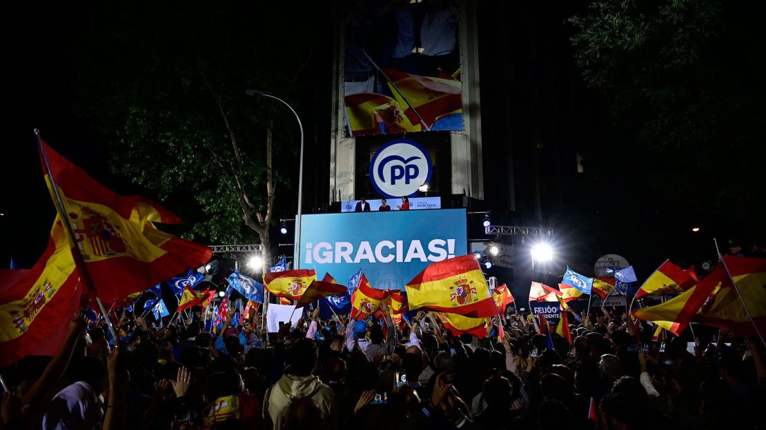 Los simpatizantes del Partido Popular (PP) ondean banderas mientras se reúnen para celebrar el resultado de las urnas frente a la sede del partido en Madrid el 28 de mayo de 2023 después de las elecciones locales y regionales celebradas en España.