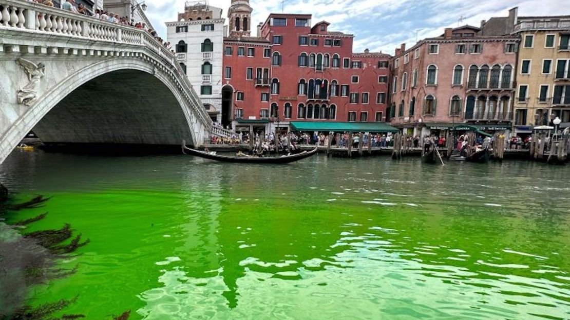 Góndolas navegan junto al puente de Rialto, en el histórico Gran Canal de Venecia, mientras una mancha de líquido verde fosforescente se extiende en él, el domingo 28 de mayo de 2023.