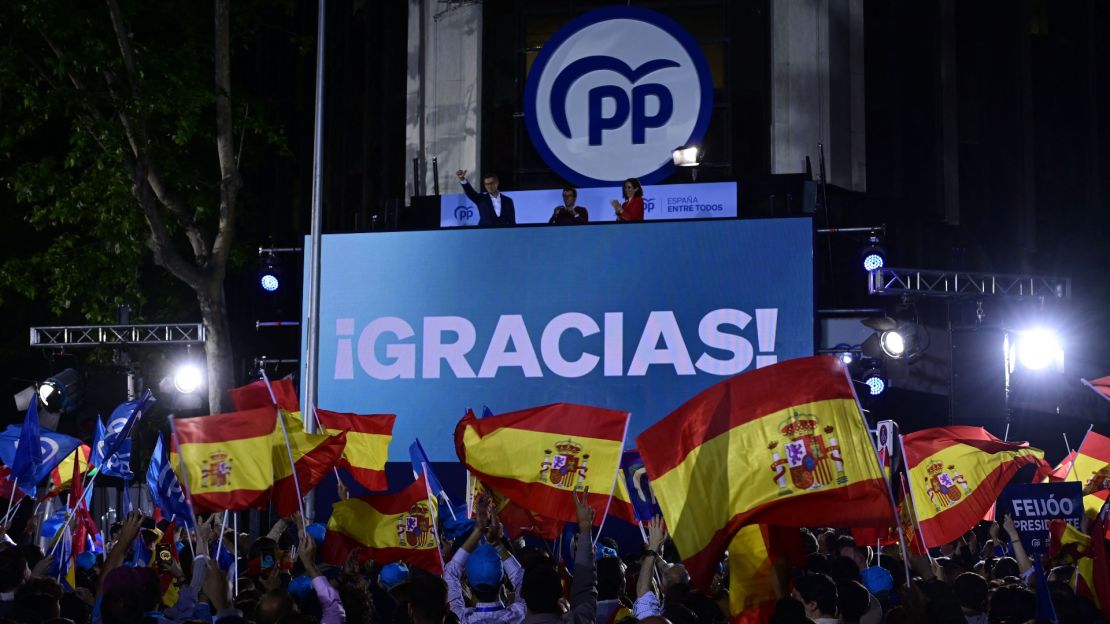 Simpatizantes del Partido Popular (PP) ondean banderas mientras se reúnen para celebrar el resultado en las elecciones municipales y autonómicas de 2023.