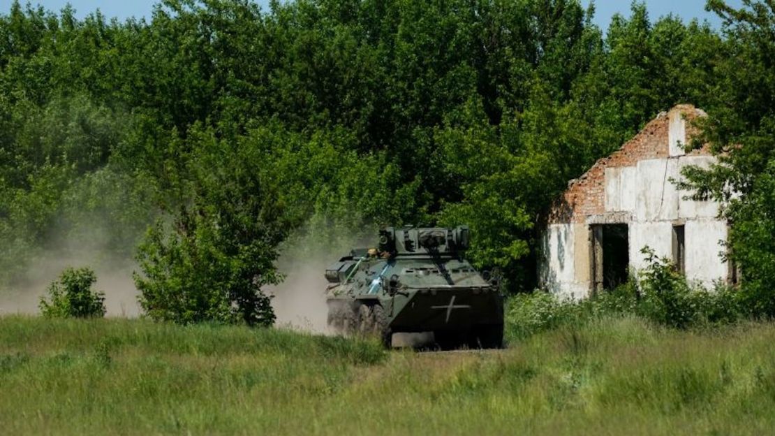 Un vehículo blindado de transporte de tropas BTR ucraniano corre por un campo como parte de un ejercicio militar.