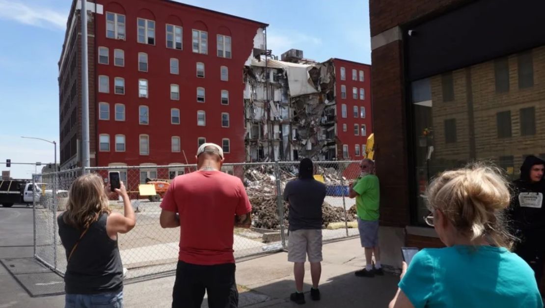 Varios transeúntes observan los restos de un edificio de apartamentos parcialmente derrumbado el lunes en Davenport, Iowa.Scott Olson/Getty Images